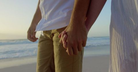 Romantic Couple Holding Hands on Beach During Sunset Walk - Download Free Stock Images Pikwizard.com