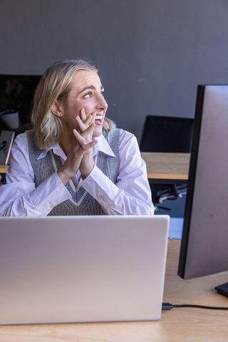 Focused female professional working dual screens in modern office