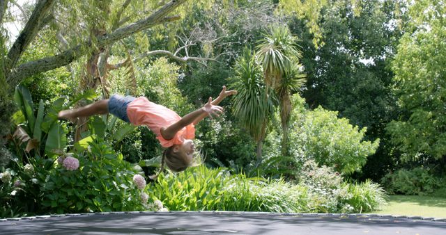 Girl Doing Backflip on Trampoline in Lush Backyard Garden - Download Free Stock Images Pikwizard.com