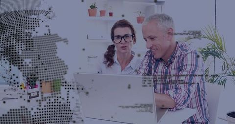 Business professionals collaborating on laptop with digital graphics