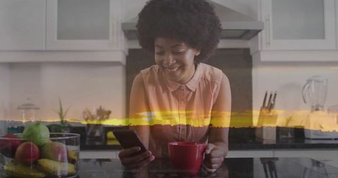 Woman Checking Smartphone with Coffee in Modern Kitchen