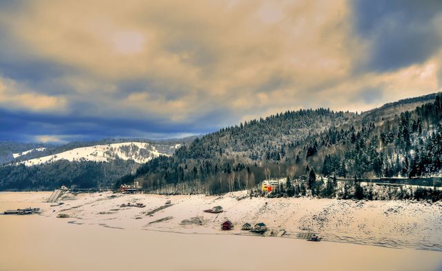 Snow-covered Mountains and Houses by Frozen Lake at Sunset - Download Free Stock Photos Pikwizard.com