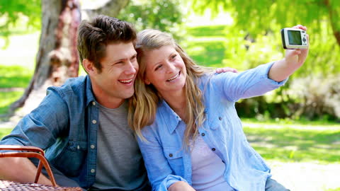 Couple Smiling Widely While Taking Selfie in Park