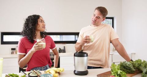 Couple Enjoying Green Smoothies in Modern Kitchen