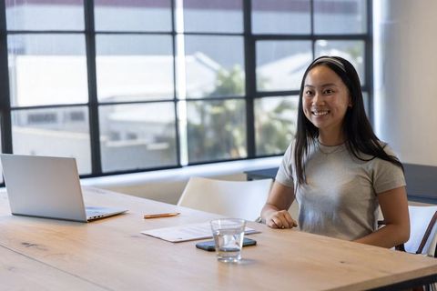 Asian Businesswoman Working on Laptop at Office Meeting Table