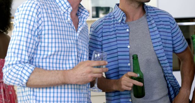 Friends Socializing While Holding Beer in Modern Kitchen - Download Free Stock Images Pikwizard.com