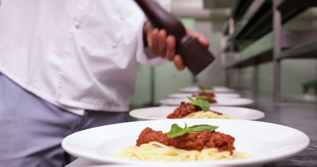 Chef Seasoning Spaghetti Bolognese in Professional Kitchen - Download Free Stock Images Pikwizard.com