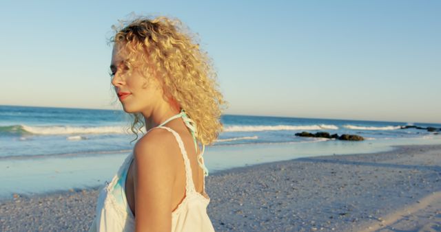 Woman with Curly Hair Enjoying Serene Beach Sunset - Download Free Stock Images Pikwizard.com