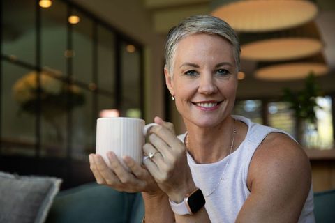 Smiling Senior Woman Relaxing with Coffee at Home