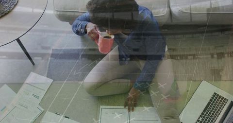 Woman Overhead Observing Documents at Home Office with Coffee
