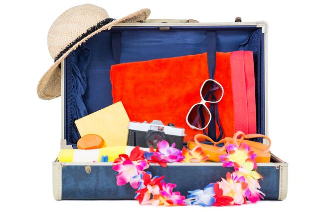 Open suitcase containing beach vacation essentials such as a straw hat, sunglasses, a camera, a bright orange towel, flip-flops, sunscreen, and a colorful lei. Ideal for travel blogs, vacation planning websites, and summer holiday promotions.