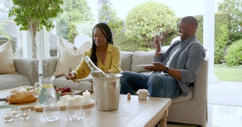 Mature Couple Relaxing Indoors with Snacks and Drinks