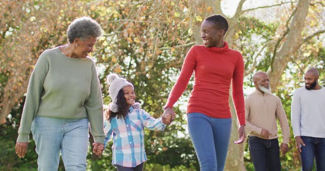 Image of happy african american mother, daughter and grandmother walking in garden holding hands - Download Free Stock Photos Pikwizard.com
