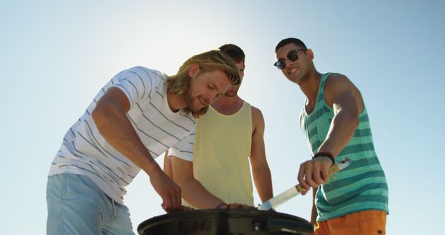 Young Friends Barbecuing at Beach on Sunny Day - Download Free Stock Images Pikwizard.com