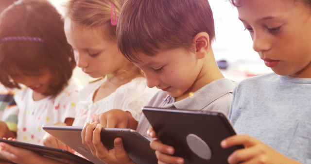 Diverse group of young children enjoying screen time on tablets. Perfect for educational content, advertisements about children's tech products, classroom activities, and campaigns promoting digital literacy.