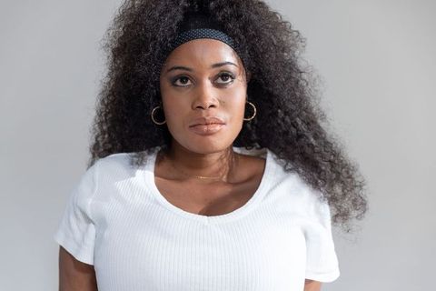African american woman wearing white top polka dot headband hoop earrings portrait