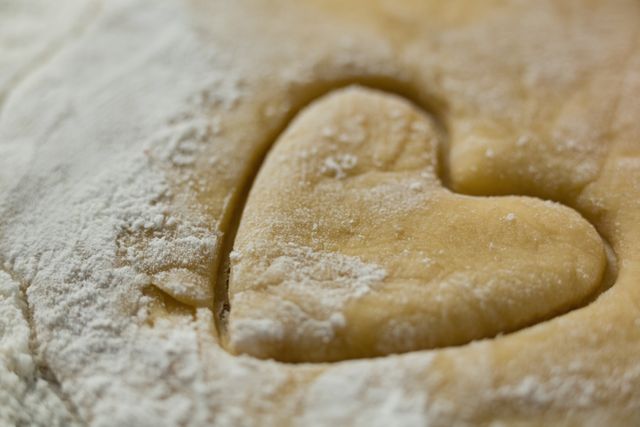 Close up of heart shape on dough with flour