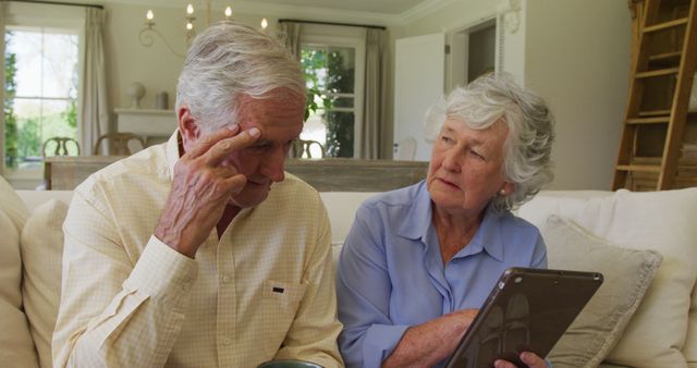 Worried Senior Couple Using Tablet at Home in Living Room - Download Free Stock Images Pikwizard.com