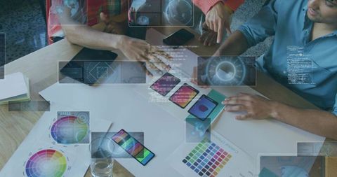 Design team collaborating on mobile ui mockups with color palettes and prototype testing