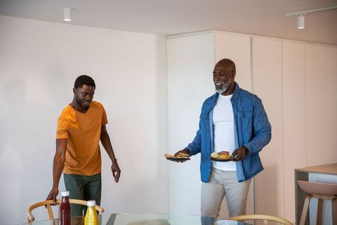 Father and Son Carrying Meals in Modern Kitchen Interior