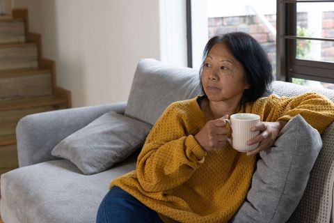 Contemplative Senior Woman Relaxing at Home with Cozy Warmth