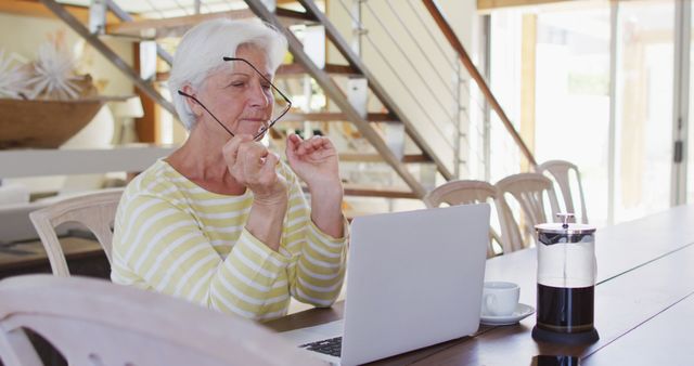 Senior woman working on laptop with coffee at home - Download Free Stock Images Pikwizard.com