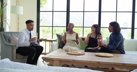 African american friends enjoying wine and conversation in sunlit farmhouse living room