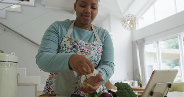 Happy african american plus size woman wearing apron, cooking in kitchen composting vegetable waste - Download Free Stock Photos Pikwizard.com