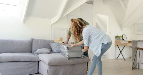 Couple packing suitcase for vacation trip