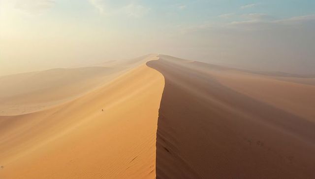 Curved sand dune ridge in tranquil desert landscape