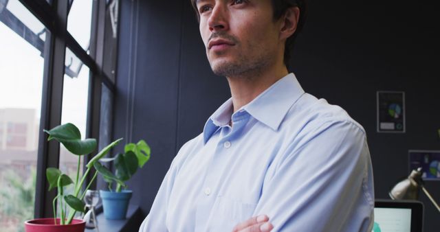 Thoughtful Young Businessman Standing in Office - Download Free Stock Images Pikwizard.com