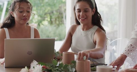 Diverse Women Collaborating on Wedding Plans Over Coffee