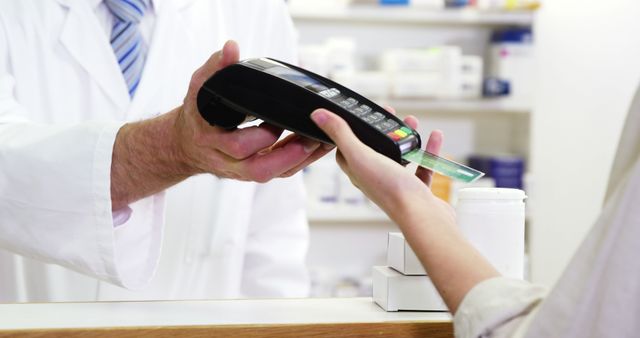 Customer using credit card for payment in a pharmacy. Could be used to illustrate concepts of modern payment methods, healthcare transactions, retail purchases, or digital payment technology. Suitable for use in articles, advertisements, and promotional materials related to pharmacies, healthcare services, and retail businesses.