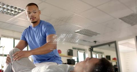 Male physiotherapist assisting patient with guided knee stretch in rehabilitation clinic
