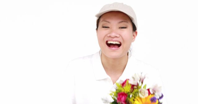 This vibrant and cheerful image features a smiling woman holding a colorful bouquet of flowers against a white background. The scene radiates happiness and joy, making it perfect for use in greeting cards, advertisements for florists, or promotional materials for events and celebrations. The clean white background allows for easy integration into various designs, creating a bright and uplifting atmosphere.