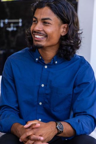 African american man smiling wearing navy collared shirt and wristwatch, casual portrait