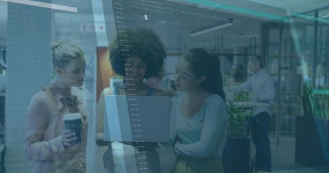 Diverse team collaborating around laptop in modern glass office with code overlay