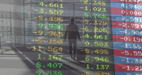 Executive walking with suitcase through glass atrium with stock ticker market data overlay