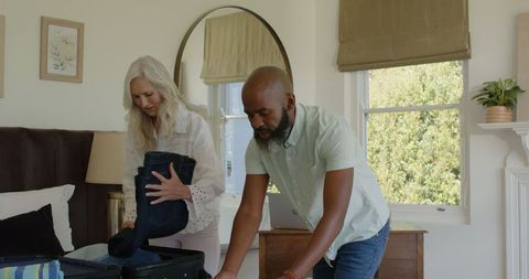 Happy Mature Couple Packing for Travel Adventure