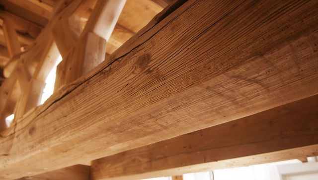 Featuring rough-sawn timber beam and exposed rafters in rustic loft architectural interior