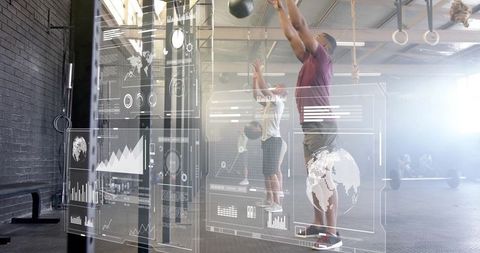 Man Performing Medicine Ball Exercises with Futuristic Display in Gym
