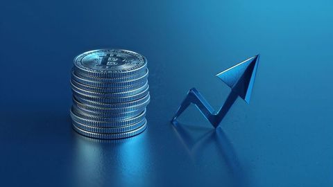 Bitcoin coins stacking beside rising arrow online trading symbol on reflective surface