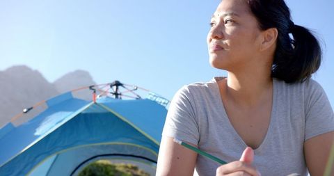 Woman journaling during mountain camping adventure