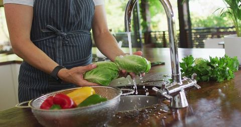 Pregnant Woman Preparing Healthy Meal with Fresh Vegetables in Modern Kitchen