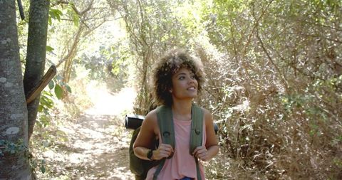 Joyful Woman Hiking Sunlit Forest Trail, Adventurous Spirit