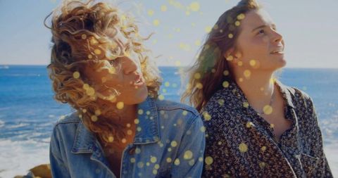 Carefree Women Gazing by Ocean on Sunny Day Adventure