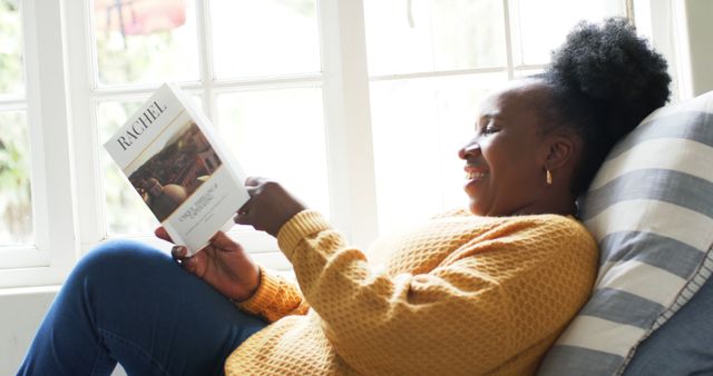 Smiling Woman Reading Book on Couch by Window - Download Free Stock Images Pikwizard.com