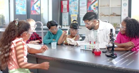 Diverse Classroom Chemistry Experiment, Teacher Guiding Students