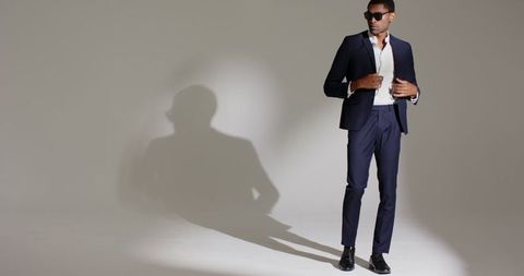 Confident Man in Navy Suit Streiking Silhouette Pose with Sunglasses