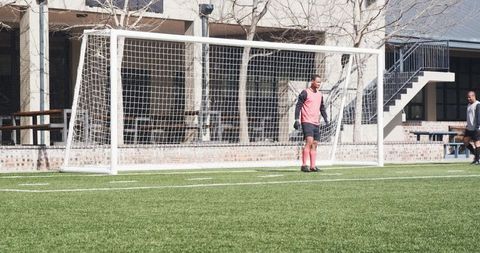 Soccer Player Standing by Goalpost on Sunny Day in Pink Jersey